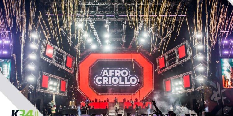 escenario de un concierto, pantalla en el centro con afro criollo